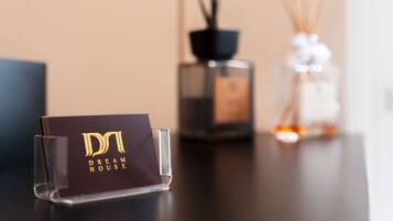 A clear glass display stand with a card that reads "Dream House" on a table.