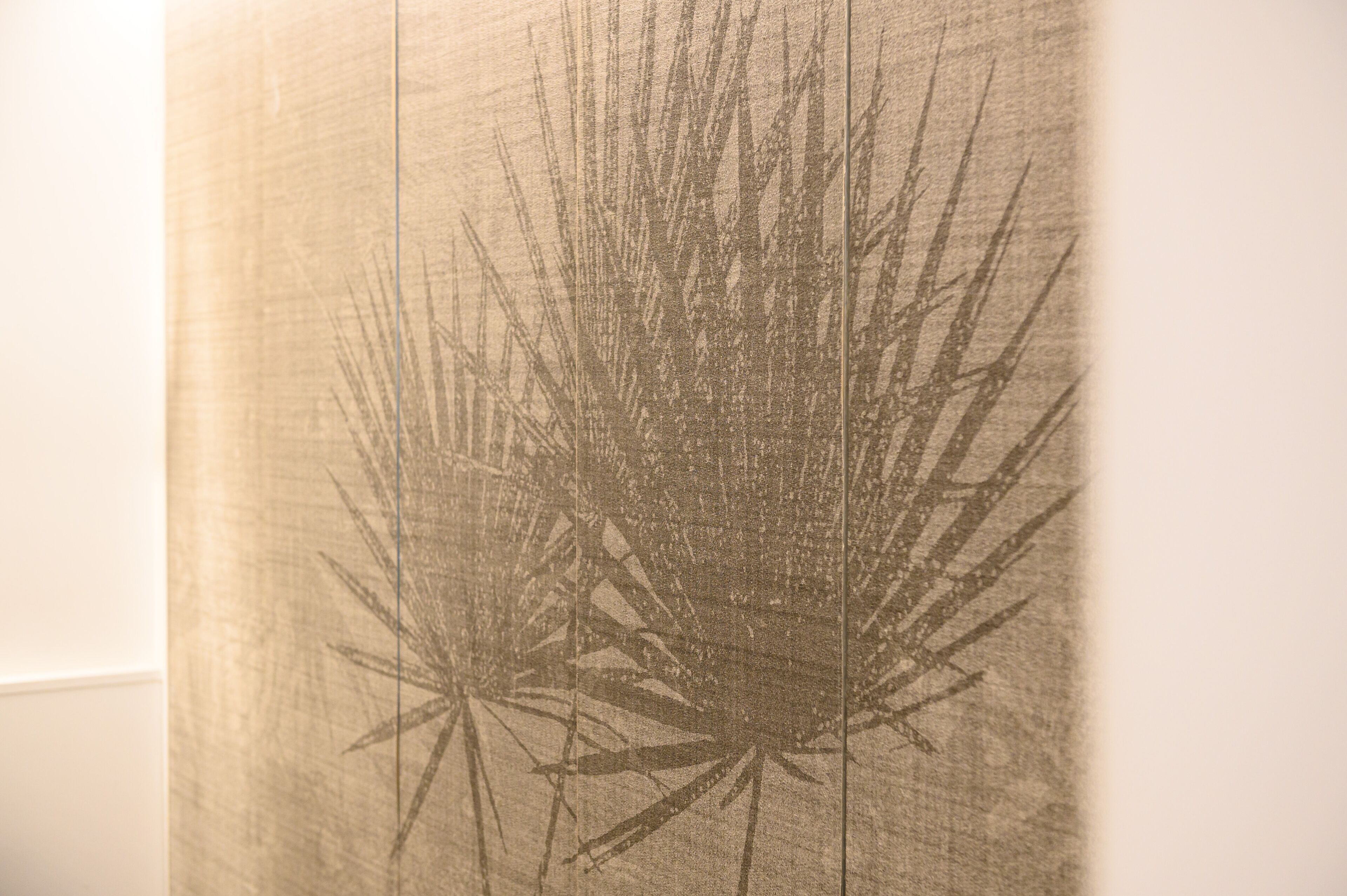 A textured wall with a botanical pattern.