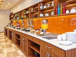 A buffet setup with various food items and a juice dispenser. - The Altruist Navi Mumbai Hotel (Navi Mumbai)
