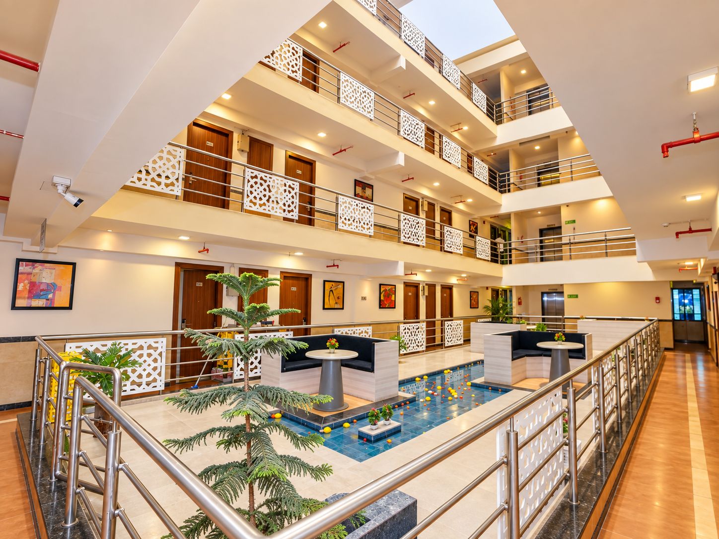 A multi-level hotel lobby with a central pool area, multiple floors, and a modern design.