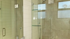 A modern bathroom with a glass-enclosed shower, a large white sink, and a mirror. - Apartments on Upton (Wanaka)