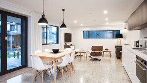 A modern kitchen with white cabinets, a granite countertop, and a built-in oven. - Dungarvon Street Apartments (Wanaka)
