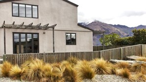 Un bâtiment moderne à deux étages, doté d’un toit plat, de grandes fenêtres et d’une clôture en bois.