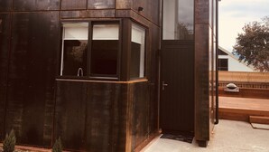 A modern building with large windows and a door. - Rusted Charm (Wanaka)