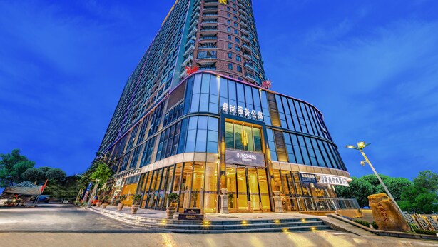 Ein modernes Hotel mit einer geschwungenen Fassade, großen Glasfenstern und auffälliger Beschilderung.