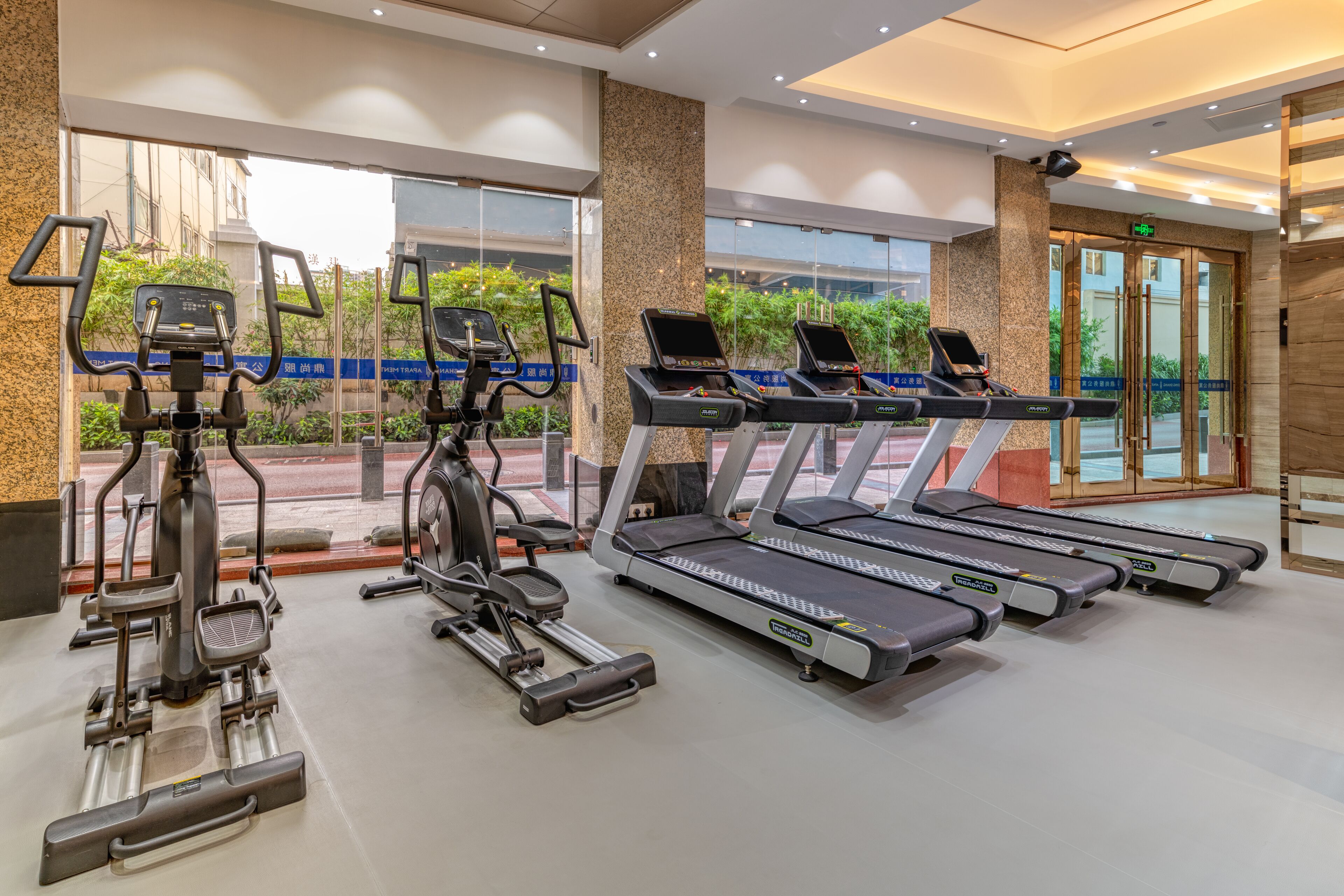 A gym with treadmills, elliptical machines, and weight equipment.