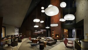 Um interior moderno com várias áreas de estar, uma lareira e luminárias pendentes exclusivas.