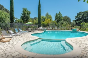 A swimming pool with lounge chairs and a stone patio. - Inn Paradiso (Paso Robles)