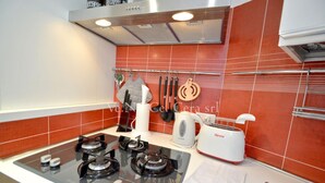 Uma cozinha com fogão a gás, torradeira e chaleira.