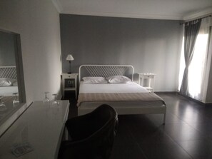 Una habitación de hotel con cama, mesitas de noche, escritorio y silla.