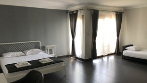 Une chambre d’hôtel avec un lit, une chaise, une petite table et un canapé.