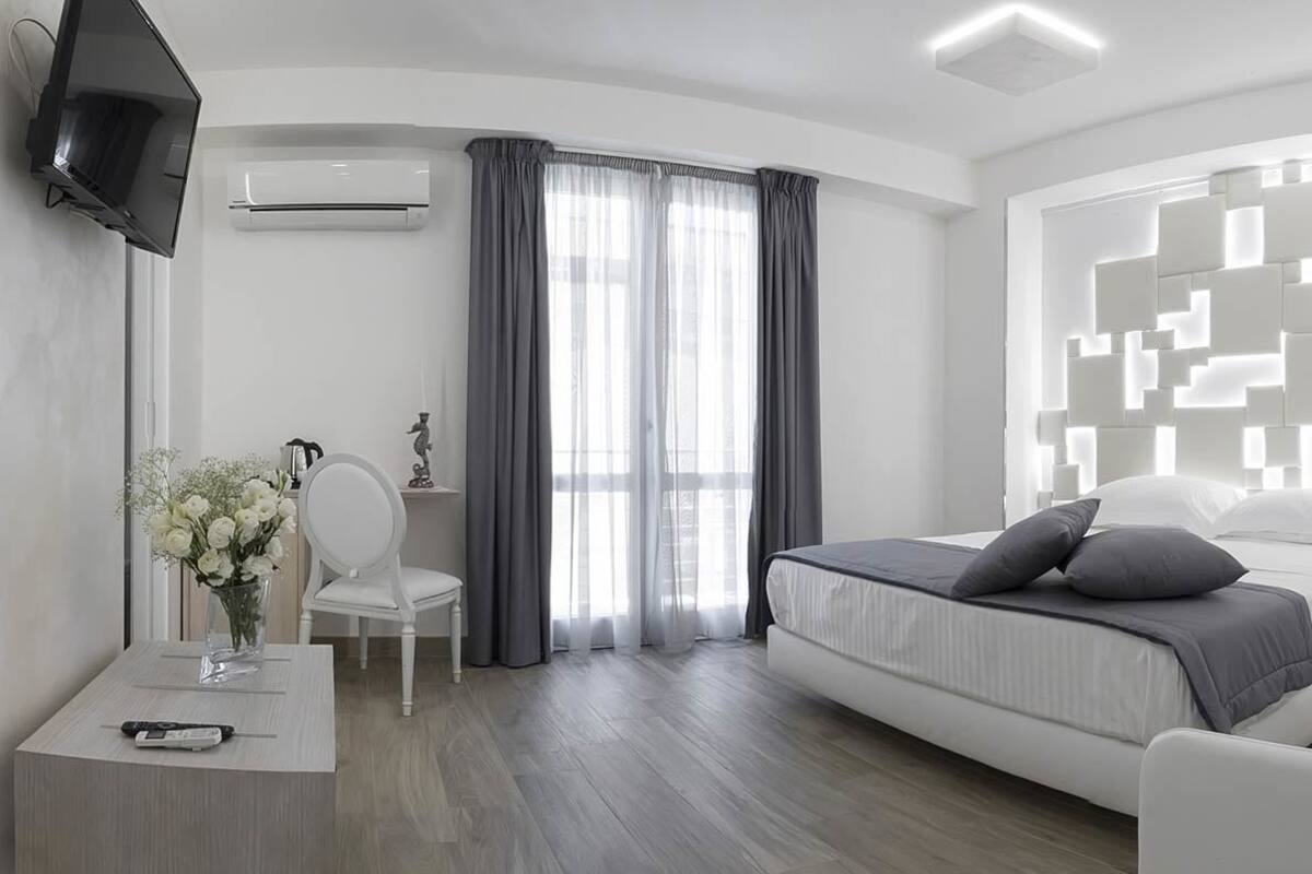 Une chambre d’hôtel moderne équipée d’un lit, d’un canapé, d’un bureau et d’une télévision.