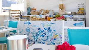 Un buffet de petit-déjeuner proposant une variété de plats et une nappe aux motifs tropicaux.