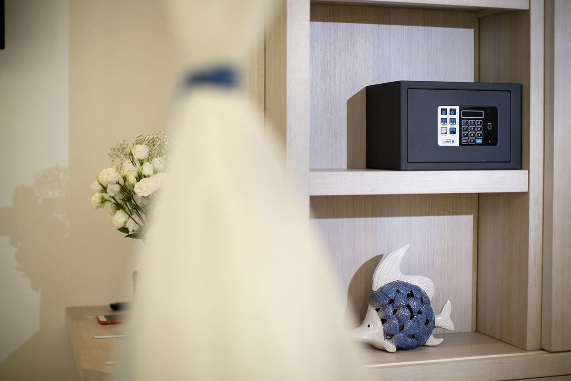 Ein Zimmer mit einem Holzkabinett, das ein schwarzes elektronisches Gerät und eine dekorative Fischskulptur beherbergt.