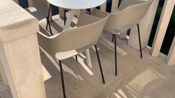 A small outdoor patio with a round table and four chairs.