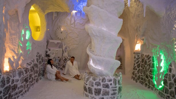 An ice cave with a central ice sculpture, stone walls, and ambient lighting. - Hotel Ortus Residence (Ankaran)