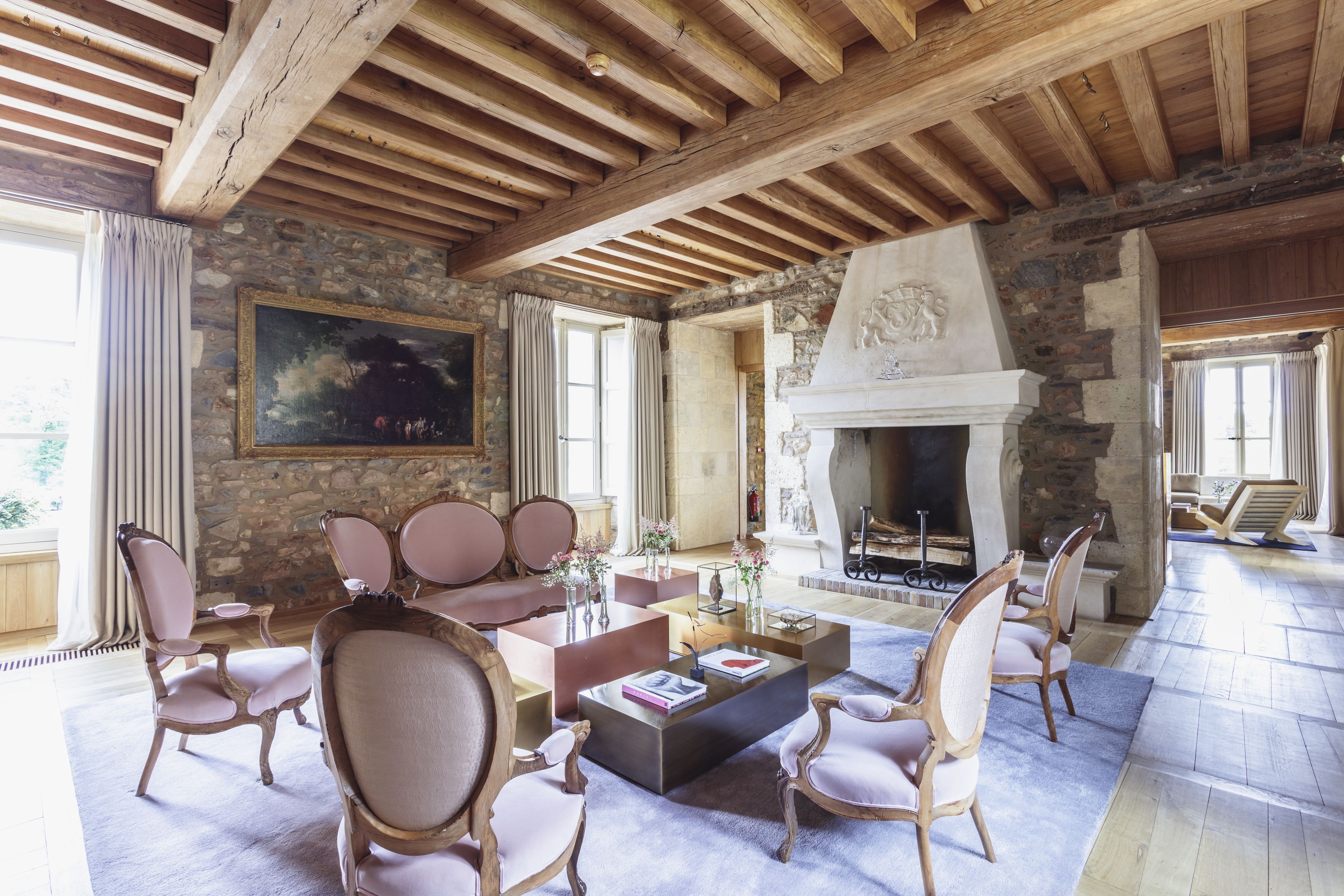 A spacious living room with a stone fireplace, wooden beams, and comfortable seating.