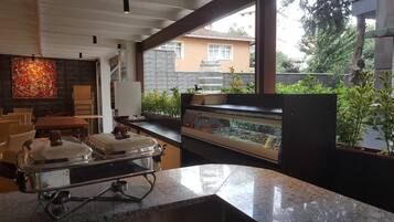 A modern kitchen with a granite countertop, a built-in oven, and a display case with food items.