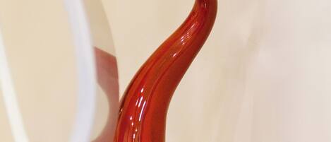 A red ceramic sculpture on a wooden surface.