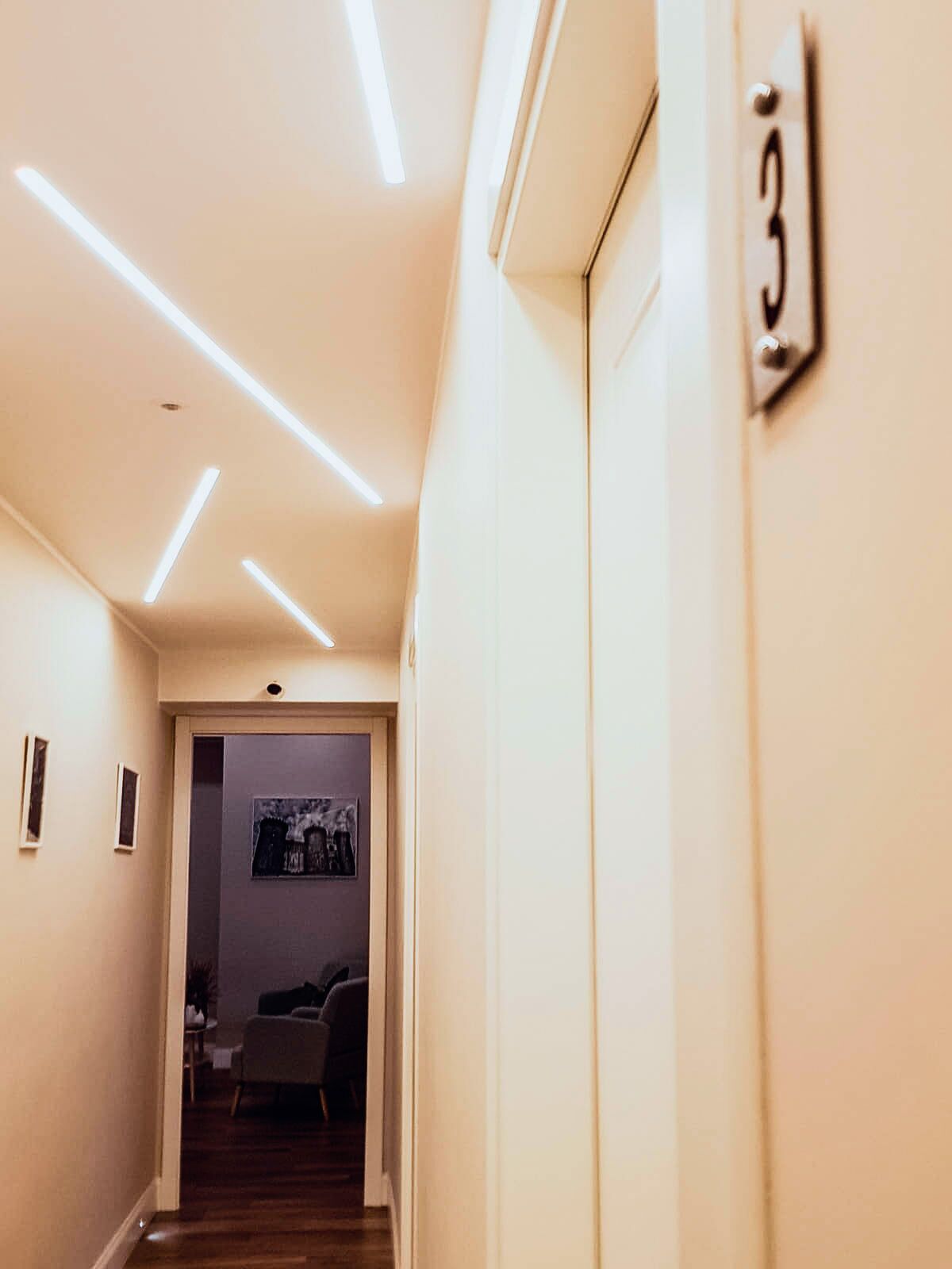 A hallway with a door labeled "3" and a framed picture on the wall.