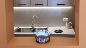 A kitchen with a built-in sink, a microwave, and a small countertop area. - HOLIDAY HOUSE MANFREDI HOME (Polignano a Mare)