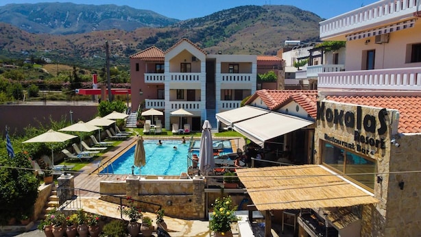 A resort with a swimming pool, outdoor seating, and a restaurant. - Kokalas Resort (Apokoronas)