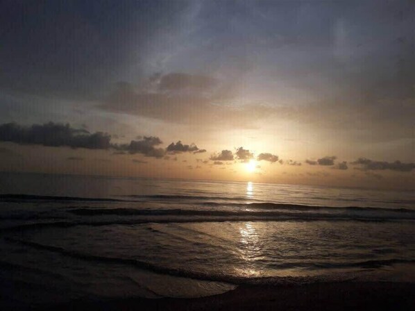Una puesta de sol sobre el océano con olas.