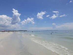 Une plage avec un ciel dégagé et une mer calme.