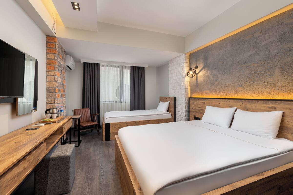 Deluxe Triple Room | Minibar, in-room safe, desk, laptop workspace