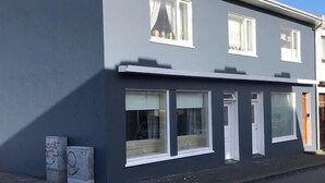 A modern two-story residential building with large windows and a flat roof. - Lava Apartment (Vestmannaeyjar)