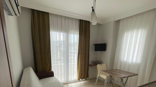 Une chambre d’hôtel équipée d’un lit, d’un bureau, d’une chaise, d’une télévision et d’un ventilateur de plafond.