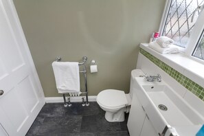 A bathroom with a toilet, a sink, and a window. - Astley 3 bedroom house (Leicester)