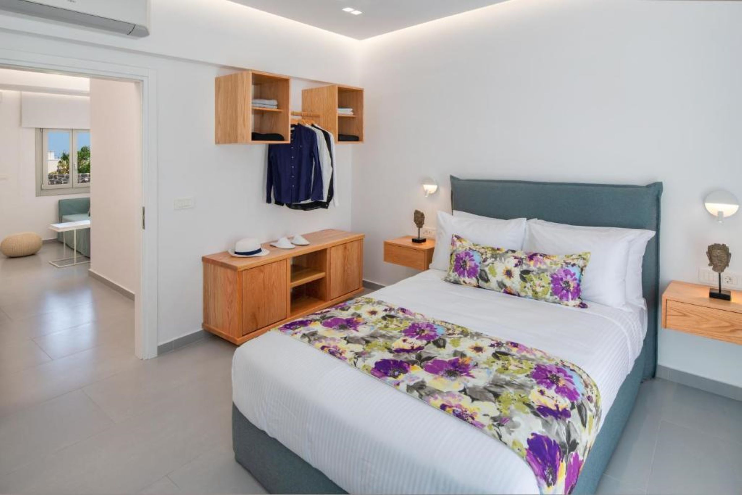 Een moderne slaapkamer met een bed, houten nachtkastjes, een kledingkast en een bureau.