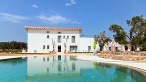 A modern building with a swimming pool in front. - Masseria Sant'Eleuterio (Collepasso)