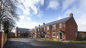 A large brick building with multiple windows and a central entrance. - Condron 3 bedroom house (Worksop)