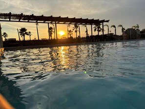 A swimming pool with a sunset in the background. - Villaggio San Demetrio (Carlentini)