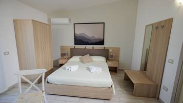 Una camera da letto moderna con un letto, comodini, una panca e un armadio.
