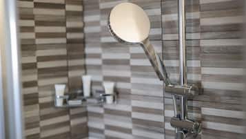 Een moderne douche met een handspiegel en een bedieningspaneel aan de wand.