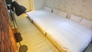 Una habitación con una cama grande, una lámpara de pie y una pared con texto repetido.