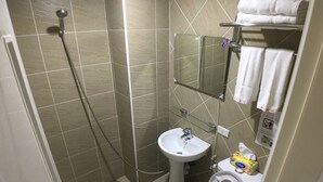 Un baño con ducha, lavamanos e inodoro.