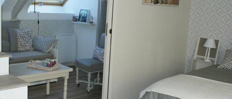 Un dormitorio con tragaluz, cama, escritorio y silla.