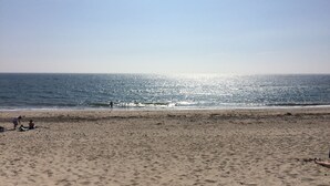 Una playa con cielo despejado y mar tranquilo.