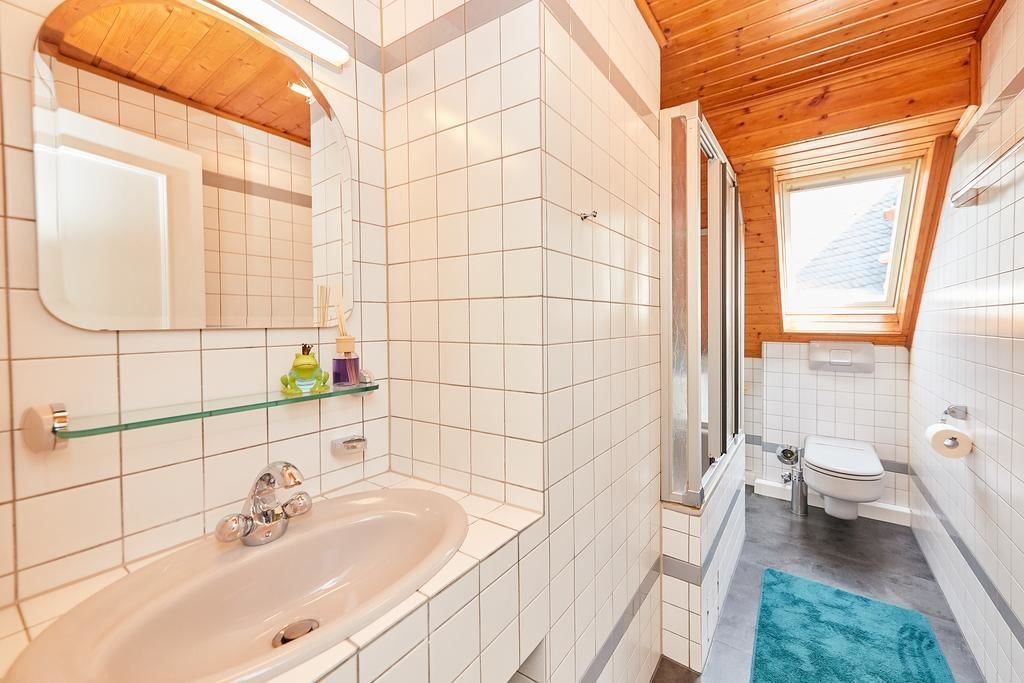 Un baño con bañera, inodoro y ventana.