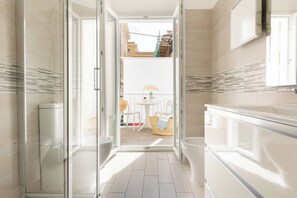 A modern bathroom with a glass shower enclosure, a toilet, and a bathtub. - Residence Bike and Beach (Finale Ligure)