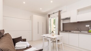 A modern kitchen with white cabinets, a dining table, and a built-in stove.