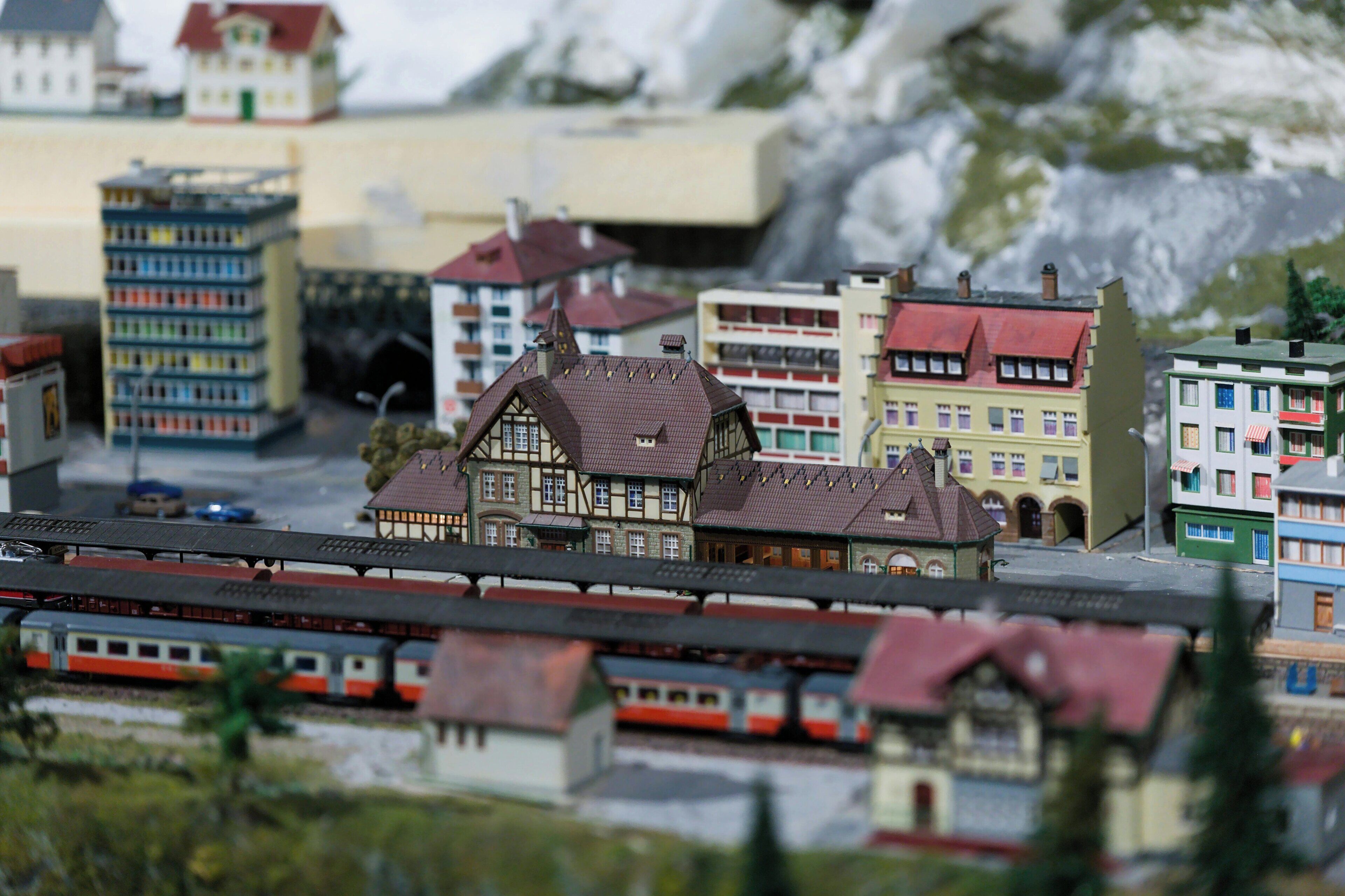 A model train set with a station, buildings, and tracks.