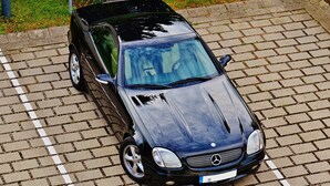 A black car parked on a paved surface.