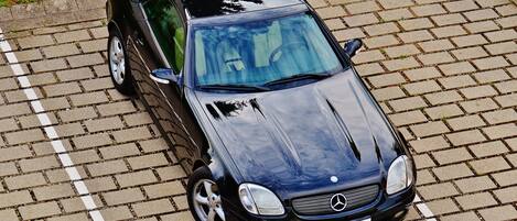 A black car parked on a paved surface.
