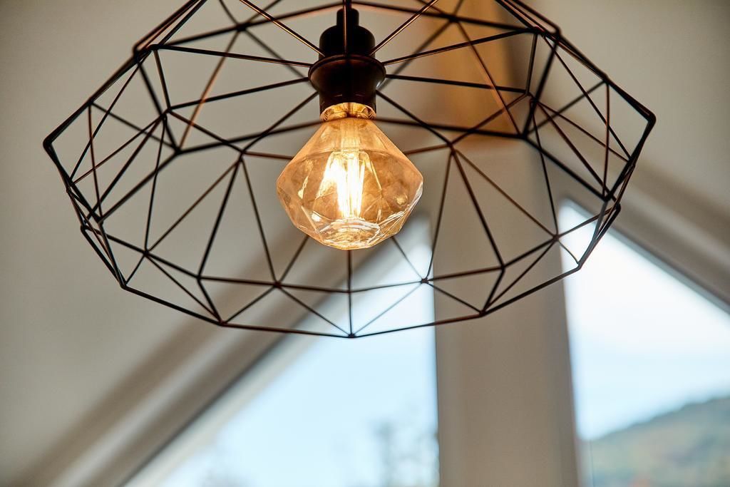 A geometric metal light fixture with a visible filament bulb.