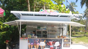 A food kiosk with a sign reading "Amazing Fruit Kingdom" and a chalkboard menu.